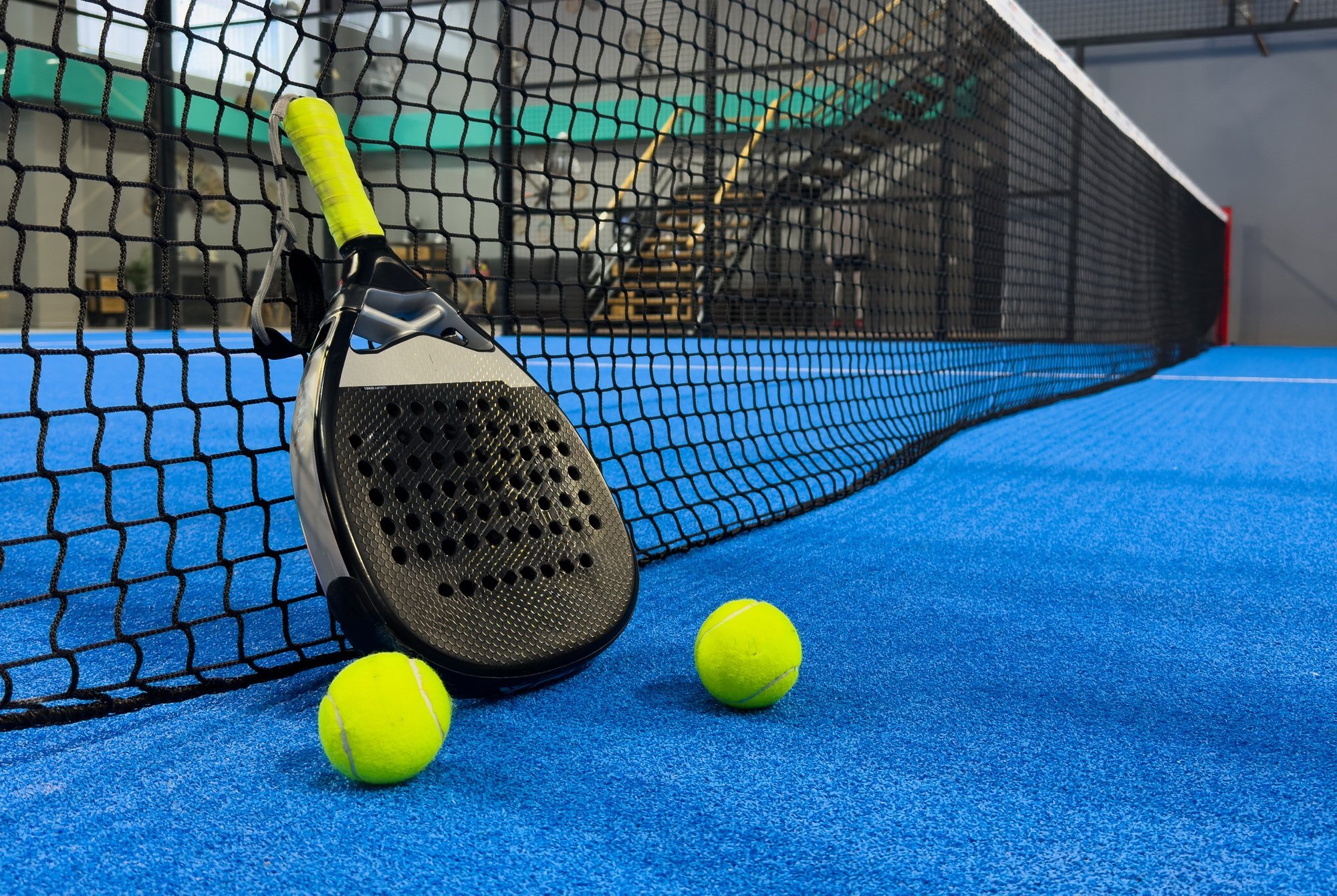 padel racket on a padel blue court with a ball